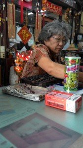 Old Chinese lady operating an abacus. Bangkok style